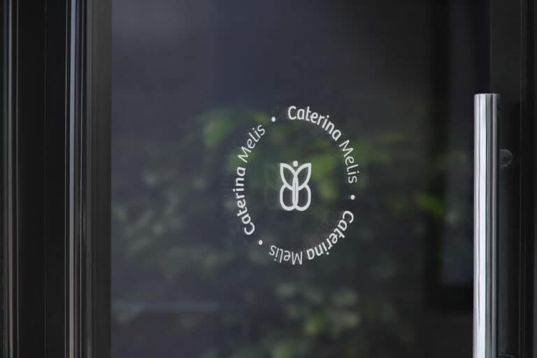 Logo Caterina Melis sobre puerta de cristal